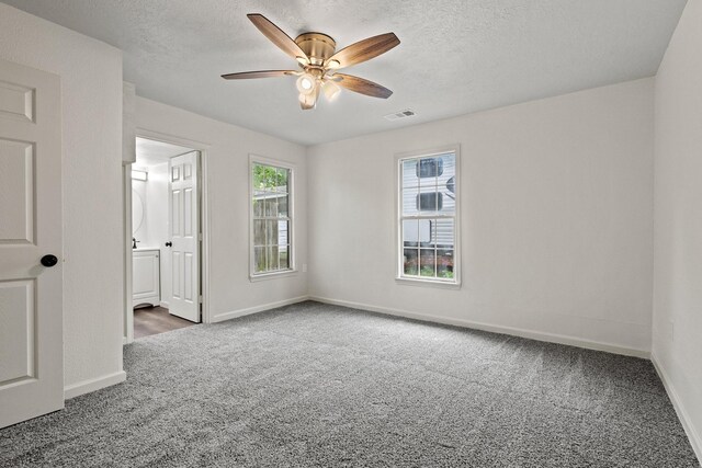 carpeted empty room featuring baseboards, a ceiling fan, and visible vents