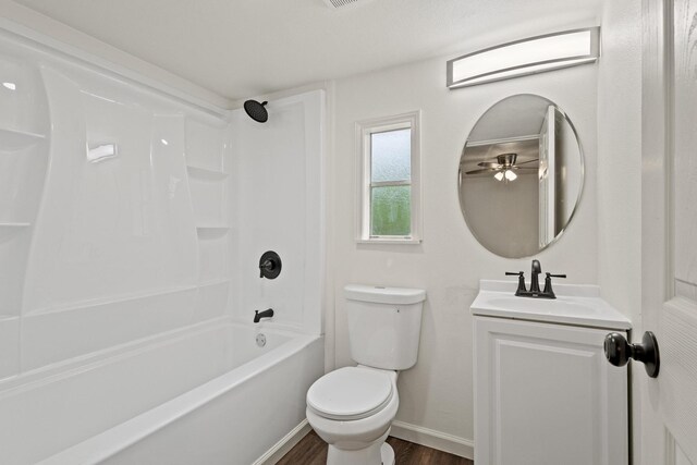 full bath with toilet, baseboards, shower / bath combination, wood finished floors, and vanity
