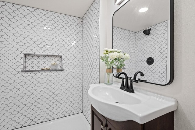 bathroom featuring a tile shower and vanity