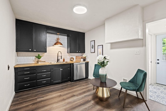bar featuring decorative backsplash, dishwasher, a sink, and dark wood-type flooring