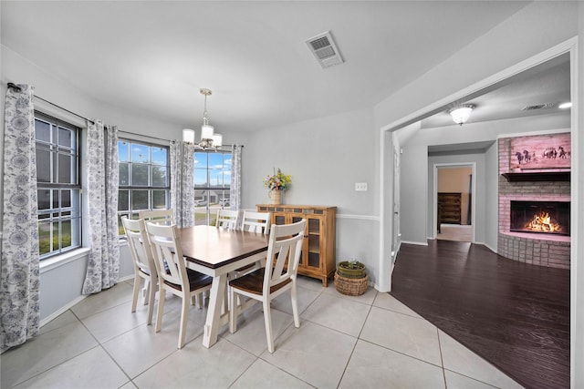 620 Linda Dr, Burleson, TX 76028 - dining area featuring visible vents, light tile patterned floors, baseboards, a chandelier, and a brick fireplace