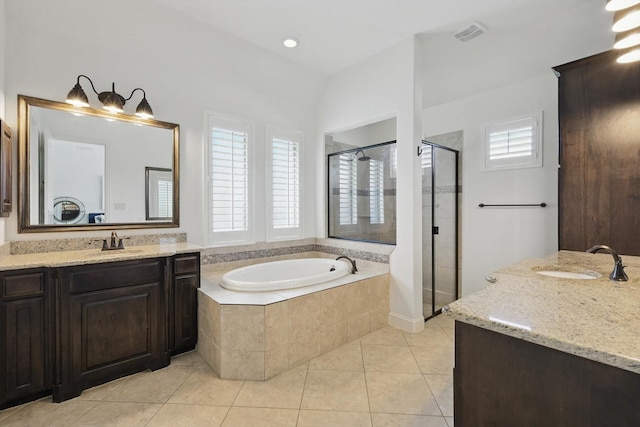 bathroom with a garden tub, a sink, a stall shower, and two vanities