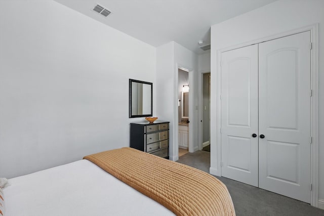 bedroom with a closet, visible vents, baseboards, dark colored carpet, and connected bathroom