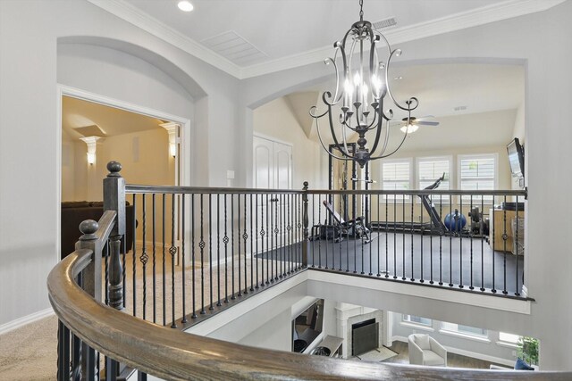 stairway with ornamental molding, carpet flooring, baseboards, a chandelier, and arched walkways