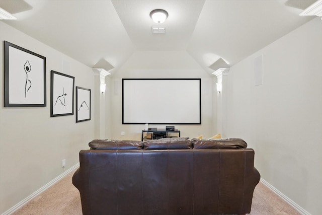 home theater room featuring ornate columns, vaulted ceiling, visible vents, and carpet