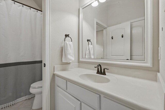full bathroom featuring toilet, tile patterned floors, and vanity