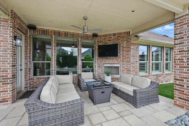 view of patio with a ceiling fan and an outdoor living space with a fireplace