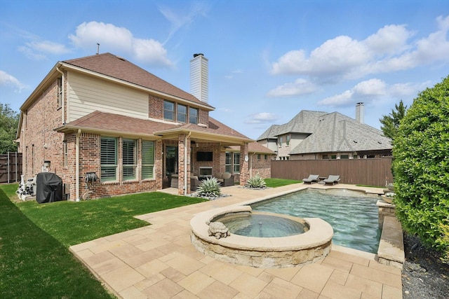 rear view of house with brick siding, a patio, a fenced backyard, and a lawn
