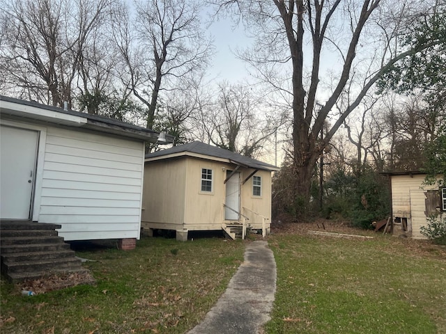 view of home's exterior featuring entry steps and a lawn