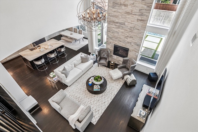 13508 Balint Ln, Frisco, TX 75035 - living area with a glass covered fireplace, wood finished floors, and an inviting chandelier