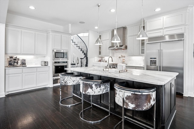 13508 Balint Ln, Frisco, TX 75035 - kitchen with dark wood-type flooring, tasteful backsplash, wall chimney range hood, and built in appliances
