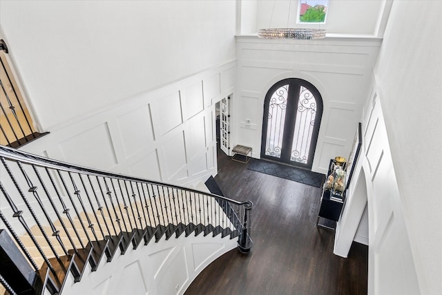 13508 Balint Ln, Frisco, TX 75035 - entrance foyer with stairs, arched walkways, dark wood finished floors, and a decorative wall