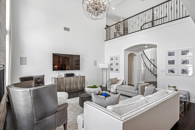 13508 Balint Ln, Frisco, TX 75035 - living area featuring arched walkways, baseboards, a towering ceiling, stairway, and dark wood-type flooring
