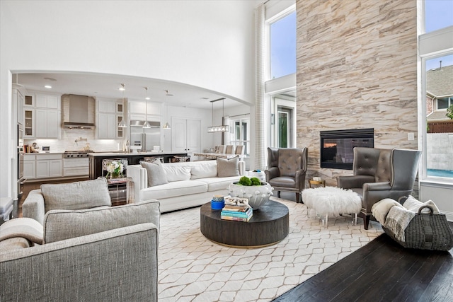13508 Balint Ln, Frisco, TX 75035 - living area with wood-type flooring, a wealth of natural light, a tile fireplace, and a high ceiling