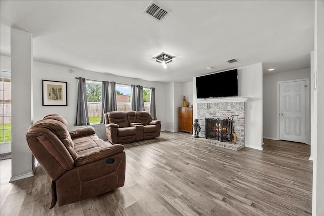 5712 Goldfinch Way, Dallas, TX 75249 - living room with baseboards, a brick fireplace, wood finished floors, and visible vents