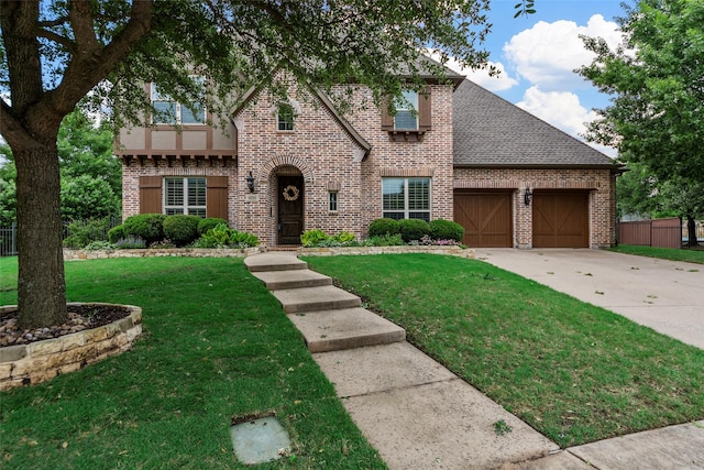 view of front of house with a garage, driveway, a front lawn, and brick siding