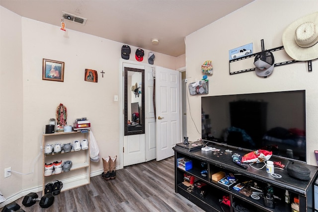 interior space with baseboards, wood finished floors, and visible vents