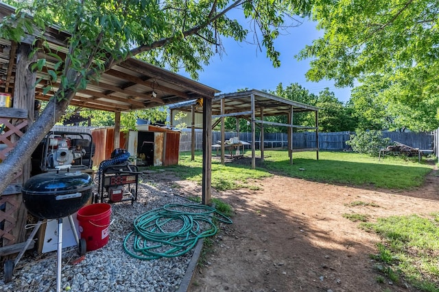 view of yard with a fenced backyard, an outdoor structure, and a storage shed