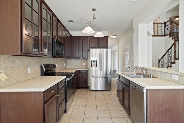 kitchen with a sink, decorative backsplash, glass insert cabinets, stainless steel appliances, and visible vents
