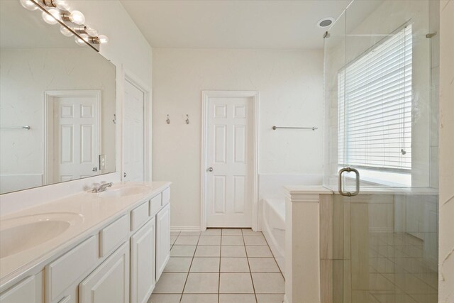 bathroom featuring a bath, tile patterned flooring, a sink, and double vanity
