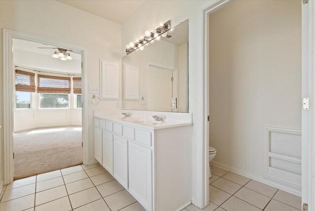 bathroom featuring a sink, built in features, double vanity, toilet, and tile patterned flooring