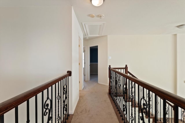 hall with attic access, carpet floors, and an upstairs landing