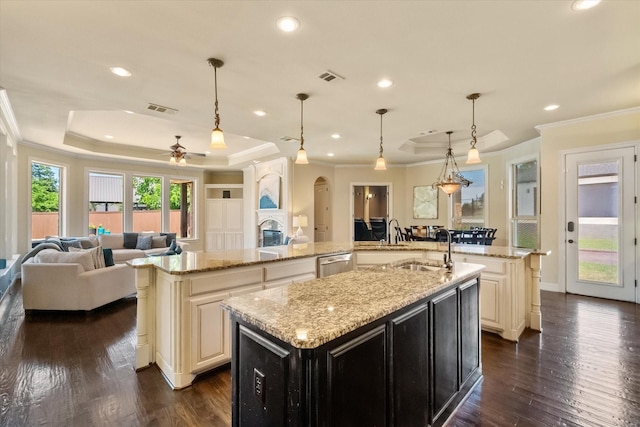 kitchen with a sink, a large island, open floor plan, visible vents, and ornamental molding