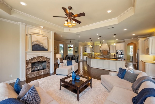 living room with visible vents, ornamental molding, a raised ceiling, and dark wood-style flooring