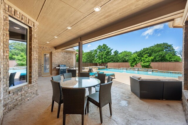 view of patio / terrace with area for grilling, a fenced backyard, grilling area, outdoor dining area, and a pool with connected hot tub