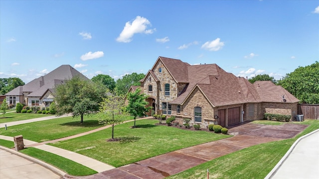 view of front of property with an attached garage, driveway, stone siding, and a front lawn