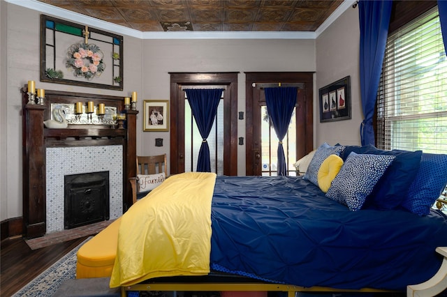 bedroom with ornamental molding, an ornate ceiling, and wood finished floors