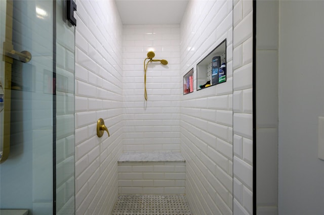 full bathroom with tile patterned flooring, tile walls, and tiled shower