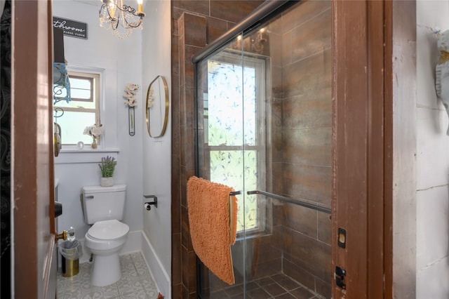 bathroom featuring toilet, tile patterned floors, a chandelier, and a stall shower