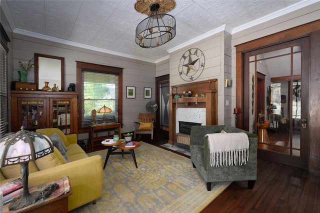 living area featuring an ornate ceiling, wood walls, hardwood / wood-style floors, a fireplace, and ornamental molding
