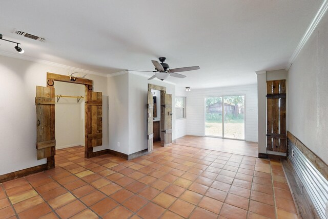 empty room with a ceiling fan, ornamental molding, visible vents, and light tile patterned floors