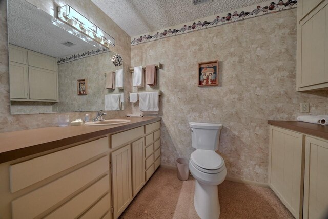 bathroom with toilet, vanity, a textured ceiling, and visible vents