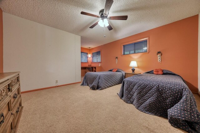 bedroom featuring carpet floors, a ceiling fan, a textured ceiling, and baseboards