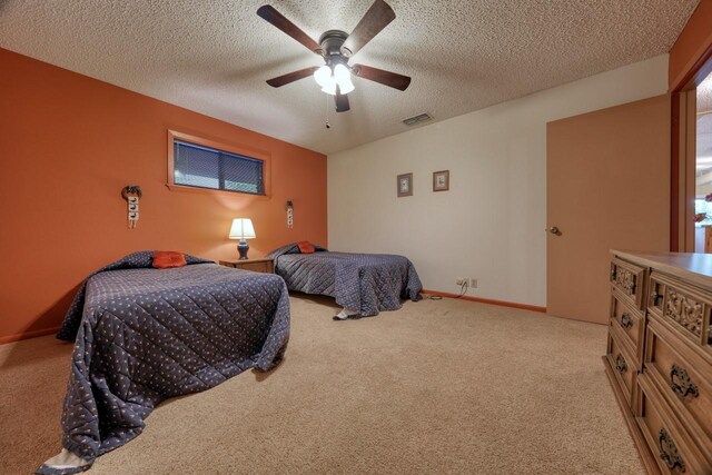 bedroom featuring a ceiling fan, a textured ceiling, carpet floors, baseboards, and visible vents