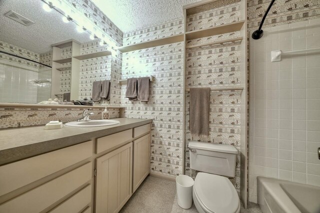 bathroom featuring visible vents, a textured ceiling, vanity, and toilet