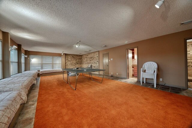 recreation room with baseboards, carpet floors, a textured ceiling, and visible vents