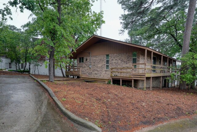 view of home's exterior featuring brick siding and a deck
