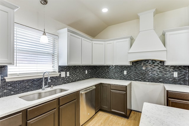 608 Piper Dr, Saginaw, TX 76179 - kitchen with vaulted ceiling, stainless steel dishwasher, a sink, light wood-style flooring, and custom range hood