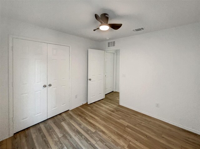 unfurnished bedroom featuring visible vents, wood finished floors, and baseboards