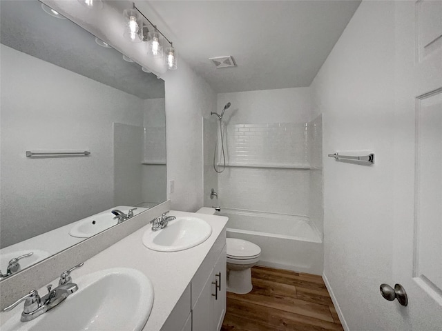 bathroom featuring wood finished floors, toilet, and a sink