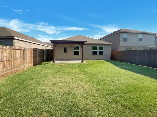 rear view of property with a patio, a fenced backyard, and a lawn