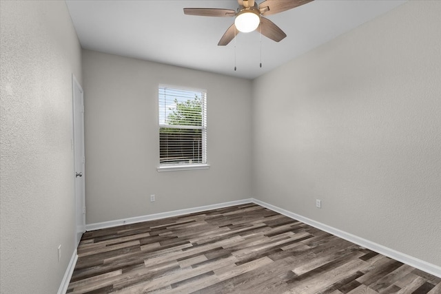 spare room featuring a ceiling fan, baseboards, a textured wall, and wood finished floors