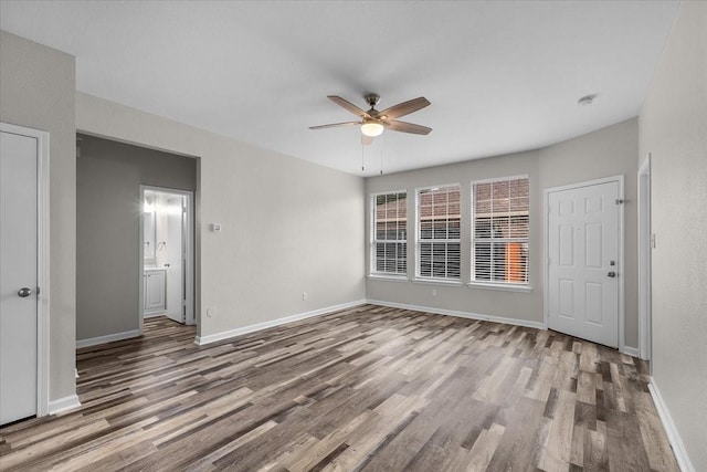 spare room featuring baseboards, ceiling fan, and wood finished floors