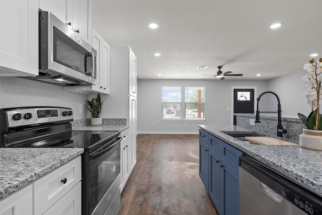 1124 Faulkner Ln, Waco, TX 76704 - kitchen with stainless steel appliances, a sink, white cabinets, recessed lighting, and dark wood-style floors