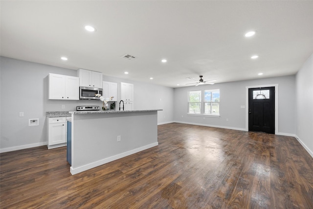 1124 Faulkner Ln, Waco, TX 76704 - kitchen with stainless steel microwave, ceiling fan, recessed lighting, white cabinetry, and range