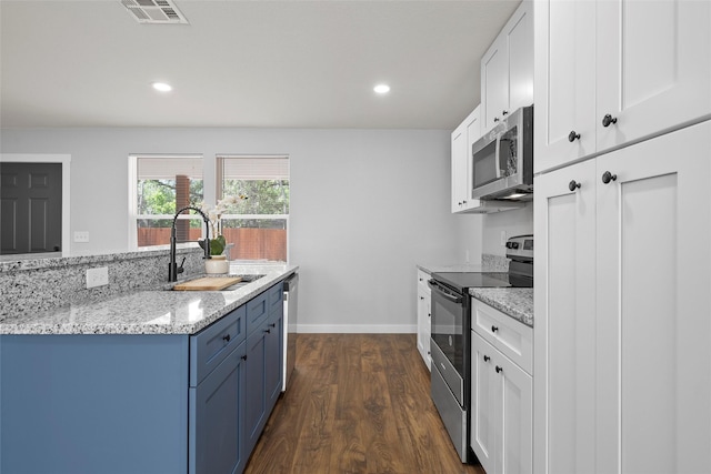 1124 Faulkner Ln, Waco, TX 76704 - kitchen featuring appliances with stainless steel finishes, a sink, white cabinetry, dark wood-style flooring, and light stone countertops